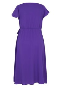 Robe violette longueur genou avec manches courtes, taille cintrée et détail noué sur le côté, vue de dos sur fond blanc.