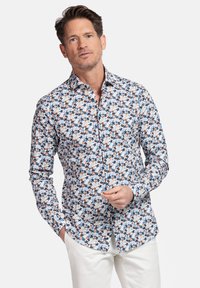 Witte overhemd met een kleurrijk bloemenpatroon in blauw, oranje en groen; heeft een getailleerd ontwerp en lange mouwen.