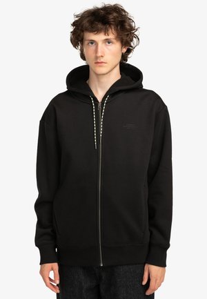 Black zip-up hoodie made of soft fabric, featuring a kangaroo pocket, ribbed cuffs, and a drawstring hood with patterned accents.