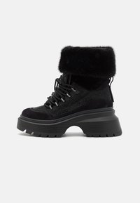 Zwarte enkellaarsjes met een faux fur manchet, materialen van suède en mesh, dikke platformzool en een opvallend vetersysteem met zilveren hardwareaccenten.