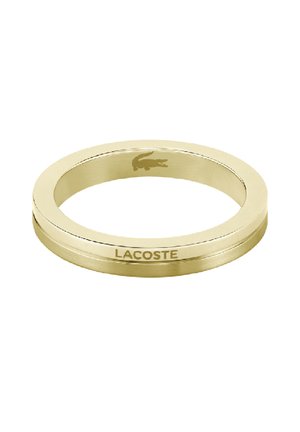 Zlatni metalni prsten s glatkom površinom, s suptilno ugraviranim Lacoste logom i okruglim oblikom. Minimalistički dizajn, bez ukrasa.