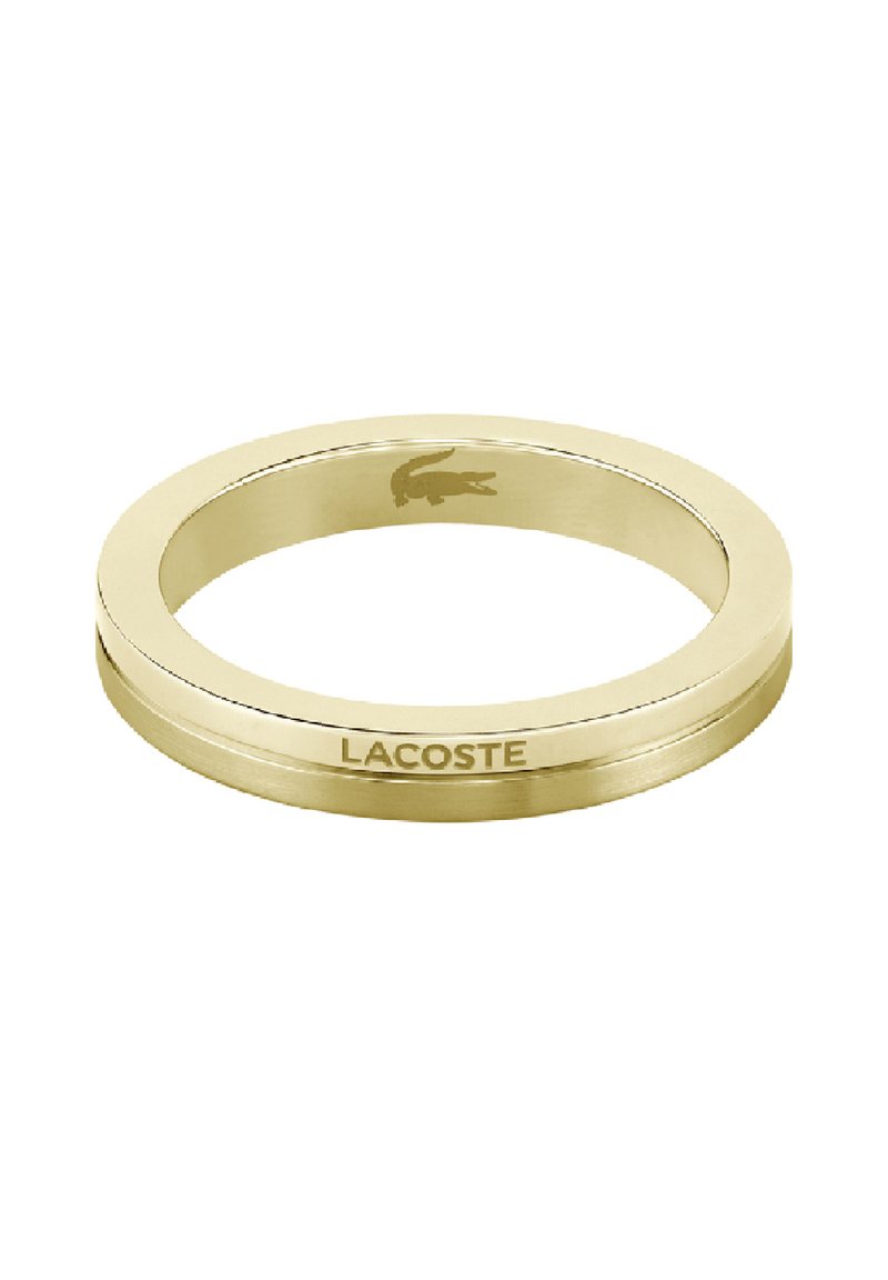 Zlatni metalni prsten s glatkom površinom, s suptilno ugraviranim Lacoste logom i okruglim oblikom. Minimalistički dizajn, bez ukrasa.