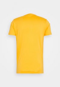 Vue de dos d'un t-shirt jaune uni à manches courtes et col rond, présenté sur un fond neutre.