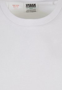 Biela organická bavlnená T-shirt s okrúhlym výstrihom, s označením starostlivosti "Uchovávajte mimo dosahu ohňa" a veľkosťou 122/128 (US 8).