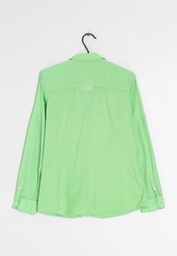 Světlězelená košile s dlouhým rukávem, vyrobená z lehkého materiálu, má límečkový výstřih, knoflíkové manžety a rovný lem s bočními rozparky.