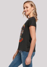Black short-sleeve t-shirt with a graphic print featuring colorful skulls and text. Regular fit, soft fabric, crew neckline.