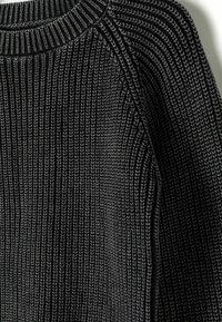 Black knitted sweater featuring vertical ribbed texture, a round neckline, and raglan sleeves. Material appears soft with a slight sheen.