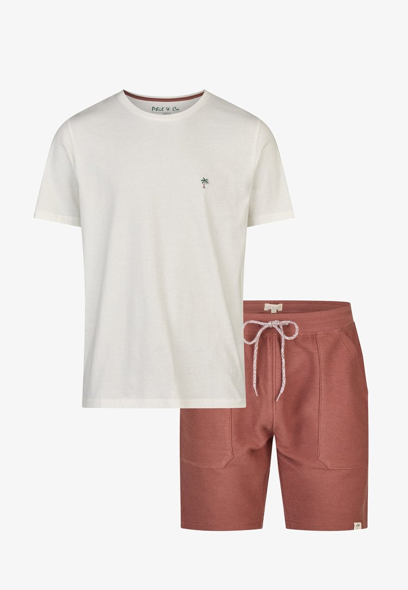 Camiseta blanca de algodón con un pequeño logotipo de palmera verde; combinada con pantalones cortos de textura color óxido, con cinturilla elástica y cordón.