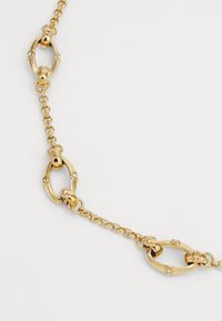 Collana d'oro con anelli ovali intervallati da piccole pietre trasparenti, design della catena testurizzato e finitura lucida.