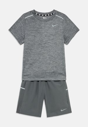 T-shirt de sport à manches courtes gris avec un logo Nike et un col à motifs, assorti à un short gris doté d'une poche latérale et du logo Nike.