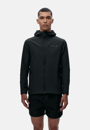 Veste noire zippée avec capuche, en tissu lisse. Présente des accents de logo blancs minimalistes sur la poitrine. Design décontracté.