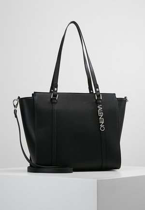 Czarna skórzana torba typu tote Valentino z podwójnymi ramiączkami oraz odpinanym paskiem na ramię, prezentowana na białym piedestale.