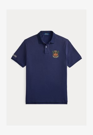 Tricou polo bleumarin din bumbac, cu mâneci scurte, nasturi cu trei găuri și logo brodat cu coroană și scut pe piept.
