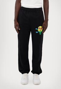 Black sweatpants with an elastic waistband and cuffs, featuring a colorful ice cream cone graphic on the right thigh.