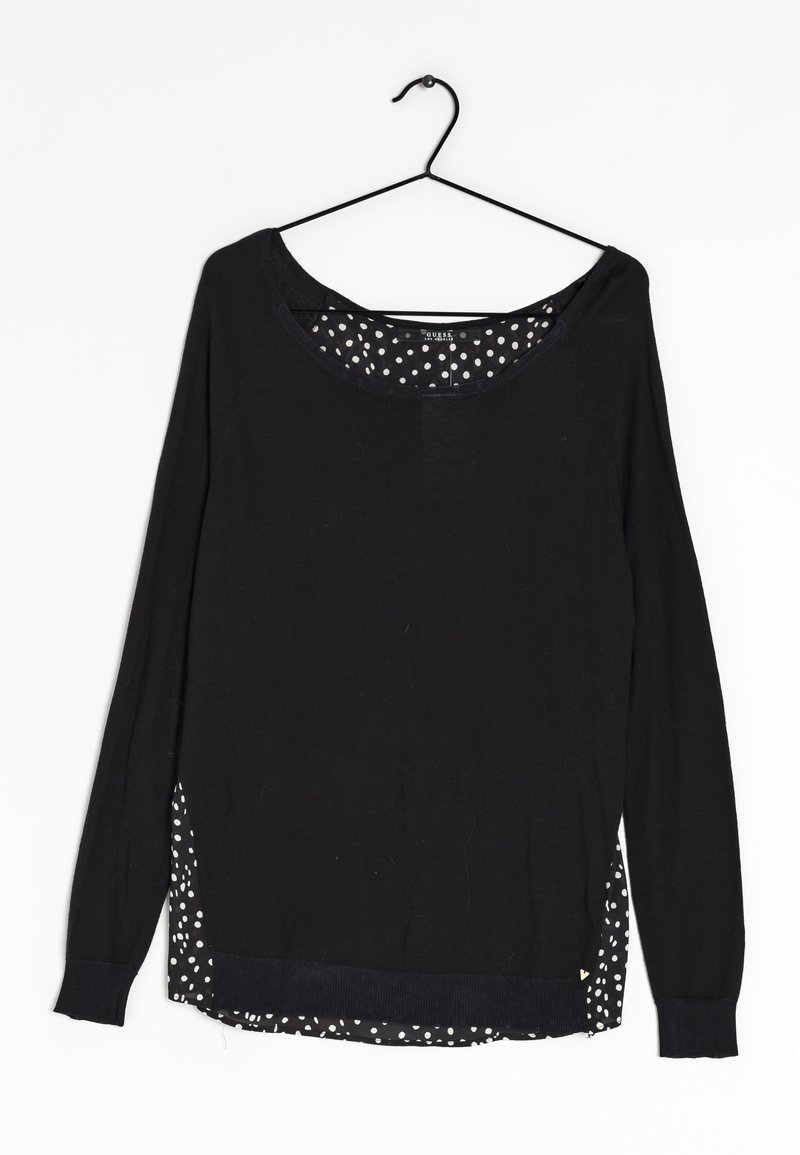 Schwarzes Langarmshirt mit rundem Ausschnitt, seitlichen Schlitzen und einem gepunkteten Muster am unteren Saum und im Inneren. Weicher Stoff.