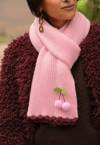 Ružová rebrovaná šalka so zúbkovanými okrajmi, obsahujúca dva ružové bambulky a pripevnené zelené listy, v kombinácii s textúrovaným burgundským kabátom.