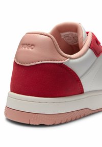 Sneaker bianco con dettagli in suede rosso e colletto imbottito rosa. Presenta una suola bianca testurizzata e un marchio impresso sul tallone.