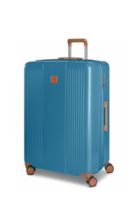 Maleta rígida en color teal con surcos verticales, mango extensible con empuñadura marrón y cuatro ruedas multidireccionales.