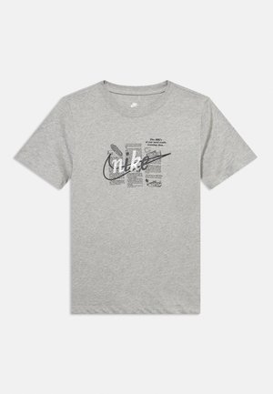 Lysegrå Nike T-shirt med sort tekst og illustrationer om træningssko, med en stor Nike swoosh-logo over fronten.