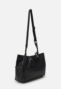 Svart texturerad axelväska med justerbar rem, silverdetaljer och ett mindre handtag mot en enkel vit bakgrund.