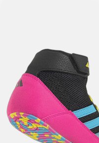 Bottines de sport montantes avec une tige en daim rose, des accents en mesh noir, des rayures bleu clair et une semelle en caoutchouc colorée et à motifs.