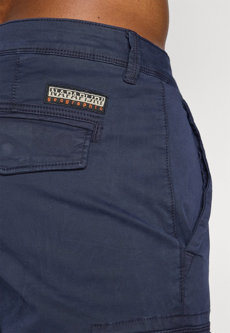 Shorts bleu marine foncé en tissu lisse, dotés d'une poche plaquée et du logo NAPAPIRJI Geographic. Comprend des détails cousus et un design durable.