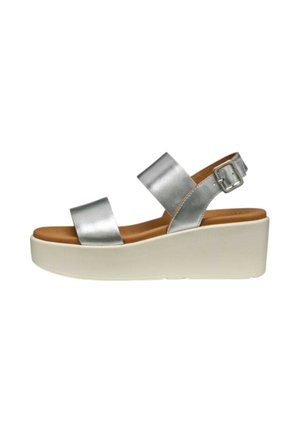 Sandalo zeppa in pelle argento con due cinturini larghi e una fibbia regolabile su una suola platform bianca, mostrato di lato.