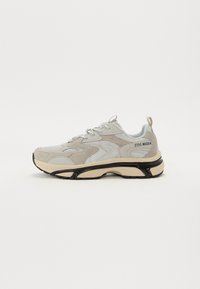Szare zamszowe i siateczkowe sneakerki z czarnymi akcentami i masywną podeszwą. posiadają białe sznurówki oraz logo "Steve Madden" na boku.
