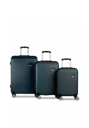 Trois valises rigides bleu marine avec des rainures horizontales, des poignées extensibles, quatre roulettes et des logos de la marque Bench, disposées par taille.