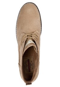 Brązowe zamszowe botki za kostkę z okrągłym noskiem, jasnobeżowe sznurowniki i teksturowane wnętrze, z metką z logo na języku.
