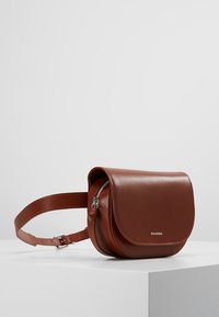 Bolso de cuero marrón cruzado con cierre de solapa, correa ajustable y una marca sutil. Textura suave con forma redondeada y detalle de cremallera.