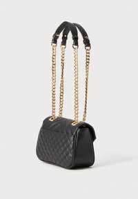 Quilted black leather handbag with gold chain straps. Features a structured shape and textured surface, showcasing distinctive stitching patterns.