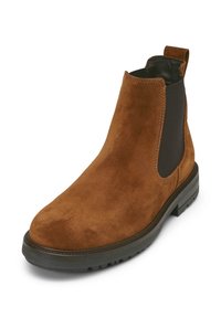Botte en daim marron à la cheville avec des panneaux latéraux élastiques, bout rond et semelle en caoutchouc texturé. Présente un empeigne noire contrastante et une languette de tirage.