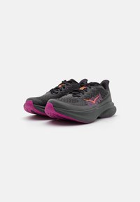 Baskets de sport noires avec une tige à motifs, dotées d'une semelle rose et d'accents orange. Conçues pour le confort avec une structure légère et rembourrée.
