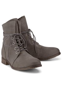 Botas de tobillo de ante gris con tacón plano, punta redonda y diseño con cordones. Cuenta con ojales plateados y una suela texturizada para mayor agarre.
