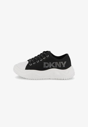 Zwarte lage sneaker met dikke witte zool, witte neuskap, zwarte veters en "DKNY" logo in witte strass steentjes aan de zijkant.