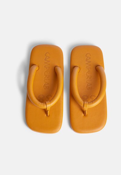 Oranje rubberen flip-flops met een gevormde zool, afgeronde teentjesstappen en een geperst logo. Soepele textuur met een minimalistisch ontwerp.