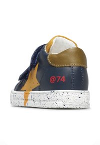Marineblaue Leder-Sneaker mit einem goldenen Akzent, featuring einem gelben Stern-Design, Klettverschluss und einer gesprenkelten weißen Sohle mit roten "@74"-Details.