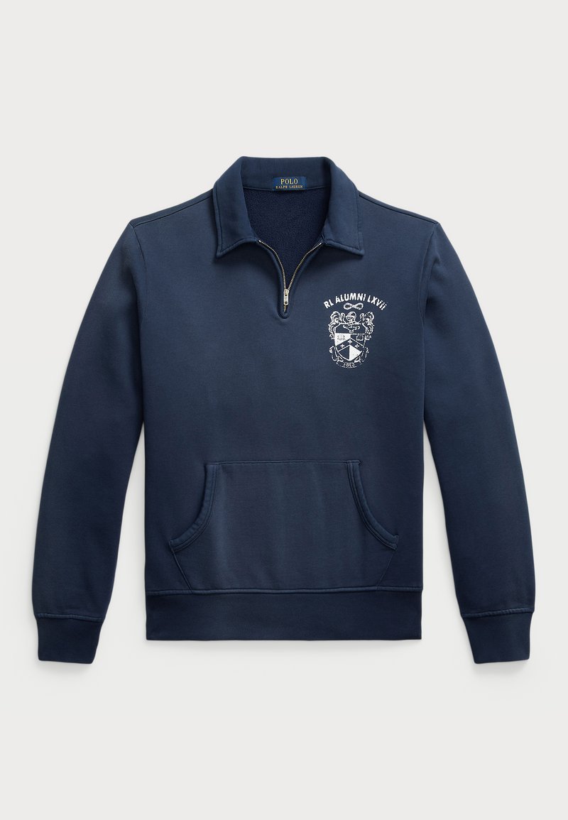 Tumesinine sviiter, millel on pooltõmbluku kaelus, ees tasku ja rinnal tikitud embleem, mis sisaldab vappi ja teksti.