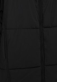 Černá péřová bunda s prošívanou texturou, předním zipem a šitými švy. Tkanina vypadá hladce a lehce. Klasický design.