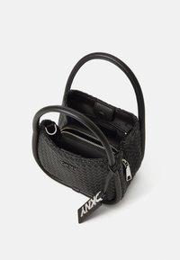 Zwarte handtas van geweven leer met dubbele handvaten, ritssluiting en zilverkleurige hardware. Het interieur bevat een klein ritssluitingzakje en een merklabel.