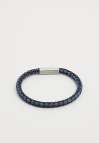 Fletet armbånd med brune og blå tekstilstrenge samt en metalisk clasp med firkantet mønster. Rund form, struktureret overflade.
