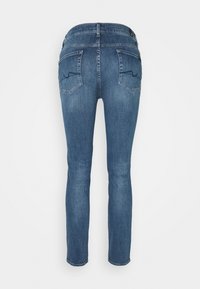 Dunkelblaue Denim-Jeans mit schmaler Passform, ausgestattet mit zwei Hintertaschen mit schräger Naht und einem mittelhohen Bund.