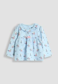 Cămașă de copil cu mâneci lungi de culoare albastru deschis, cu imprimeuri mici de zâne, guler fronsat și o fundiță roz în centrul pieptului.