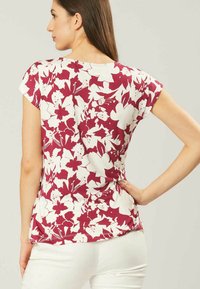 T-shirt met korte mouwen, voorzien van een rood-wit bloemenpatroon, gemaakt van zachte stof met een losse pasvorm en ronde hals.
