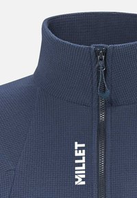 Navy fleece pullover with a high collar, featuring a central zip closure and textured fabric. "Millet" logo displayed in white.