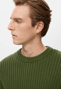 Zelený rebrovaný pletený sveter s okrúhlym výstrihom. Materiál má jemnú textúru a dizajn tvorí vertikálne línie. Jednoduchý, jednofarebný.