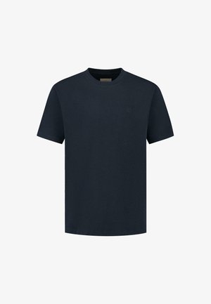 Sötétkék pamut póló, kerek nyakkivágással, rövid ujjakkal és egy diszkrét logóval a mellkasán. Sima textúra és kényelmes szabás.