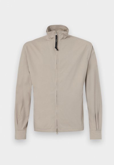 Beige letvægtsjakke med høj krave, lynlås foran, lange ærmer og elastiske manchetter. Glat tekstur, minimalistisk design uden mønstre.