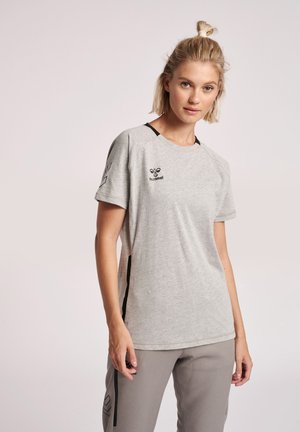 Lys grå kortærmet t-shirt med sorte accenter og logo. Har en afslappet pasform og slidser i siderne for øget bevægelse og åndbarhed.